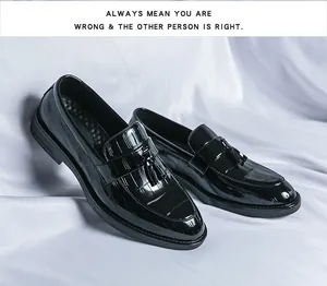 Detail view of black patent leather loafers with tassels and crocodile texture