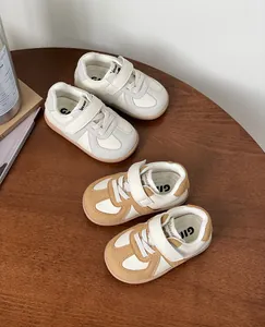 Detailed view of toddler board shoes in grey and brown on a rustic wooden table