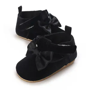 Detail view of black velvet infant walking shoes with satin bow decoration