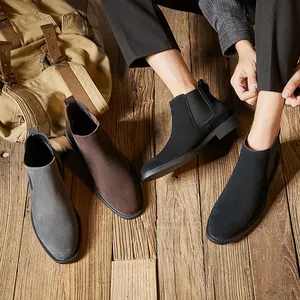 Premium men's suede Chelsea boots in grey brown and black colors on wooden background