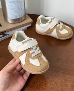 Retro toddler sneakers with soft soles and hook and loop straps in tan and white