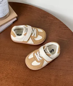 Detailed macro view of cream and tan baby sneakers with velcro straps and soft soles