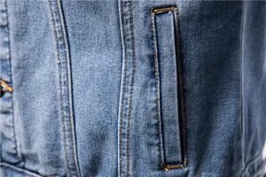 Close-up detail of men's slim denim jacket showing pocket and stitching quality.