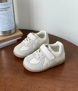 Macro detail of children's cream sneakers with grey suede overlays and Velcro straps