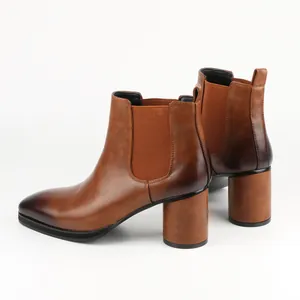Detail view showing brown high heel leather Chelsea boots with a chunky block heel