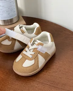 Close-up view of stylish baby sneakers with velcro strap and soft brown rubber sole