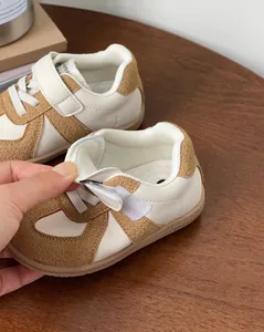 Detail showing adjustable velcro strap of brown and cream baby toddler walking sneakers.