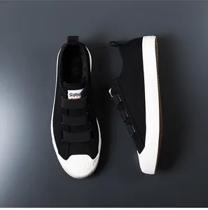 Vista detallada de zapatillas de lona negra para hombre con triple correa de velcro y suela