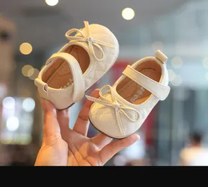 Nahaufnahme von eleganten beige gesteppten Baby Mädchen Prinzessinnenschuhen mit Schleife