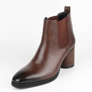 Detail view of brown men's Chelsea boots with burnished toe and block heel.