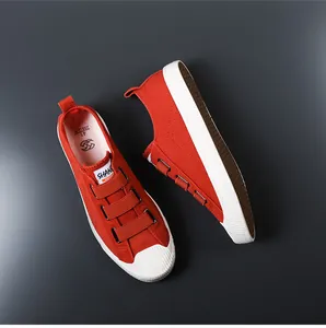 Vista detallada de zapatillas de lona roja con triple tira de velcro y puntera de goma blanca