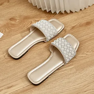 Detailed view of elegant gold square toe slides with pearl and rhinestone embellishments
