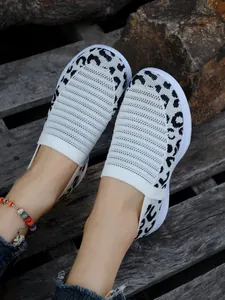 Detailansicht von stilvollen weißen Fly-Knit-Slippern mit modischem Leopardenmuster