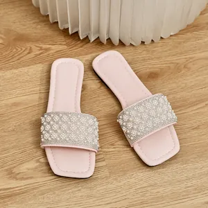 Detail view of pink square toe flat sandals featuring elegant pearl and rhinestone straps