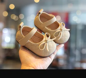 Nahaufnahme von beigen gesteppten Prinzessinnenschuhen für Babys mit eleganter Schleife