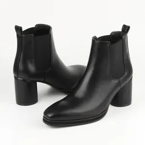 Close-up of black leather Chelsea boots with block heel and elastic side panels