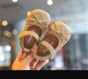 Nahaufnahme von beige gesteppten Baby-Prinzessin-Schuhen mit Schleife und Klettverschluss