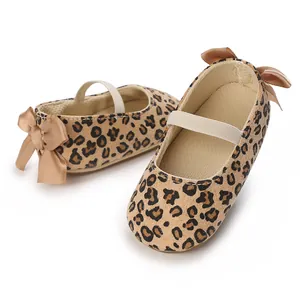Detailed view of soft-sole baby girl shoes featuring leopard print and satin bows.