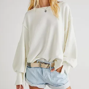 Detail van witte oversized gebreide sweatshirt met verlaagde schouders en relaxte pasvorm