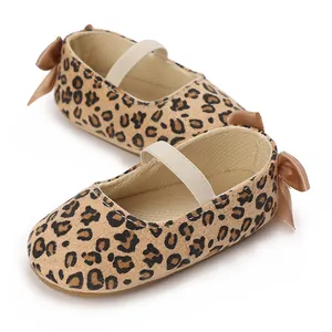 Close-up of leopard print baby shoes with elastic strap and brown bow detail