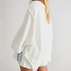 Detailopname van wit oversized sweatshirt met distressed naden en verlaagde schouder