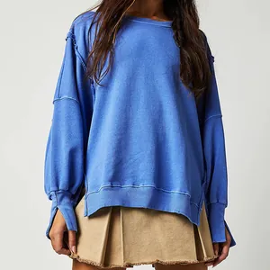 Detail van de blauwe gebreide stof en de onafgewerkte zoom van de oversized trui.