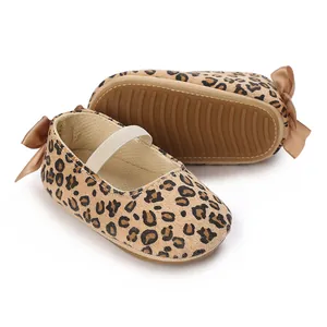 Detailed view of leopard print infant shoes featuring soft non-slip silicone soles and bows