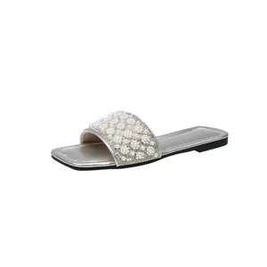 Detail of silver square toe flat sandals with elegant pearl and rhinestone strap