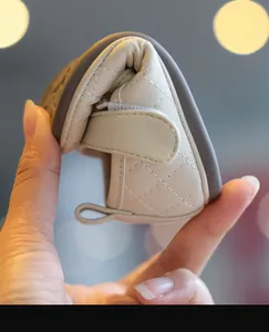 Nahaufnahme weicher beiger Lauflernschuh für Babys mit extremer Flexibilität und Steppmuster