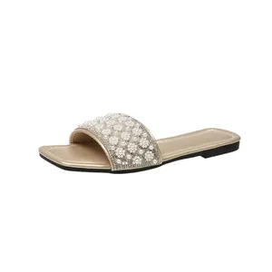 Elegant women's flat slide sandal with pearl flower and rhinestone details on strap