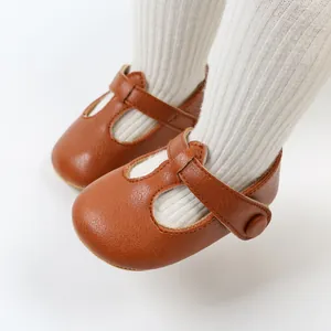 Dettaglio scarpe da camminata Mary Jane marroni per neonati con calze bianche