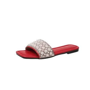Close-up of red square toe slide sandal with elegant pearl and rhinestone embellishments
