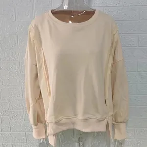 Detail van beige sweatshirt met verlaagde schouders en geribbelde manchetten.