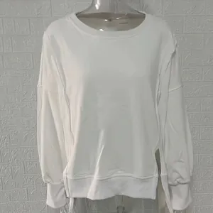 Detail van een wit ruimvallend sweatshirt met verlaagde schoudernaden en geribbelde boorden.