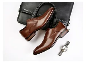 Detail view of brown genuine leather Oxford shoes with professional business props