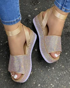 Detail view of luxury gold rhinestone platform sandals with glittery ankle straps