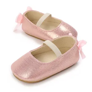 Detailed view of pink glitter baby Mary Jane shoes with soft non-slip soles and bows