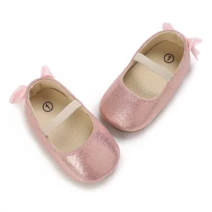 Detailed top view of shimmering pink baby Mary Jane shoes with soft soles and bows