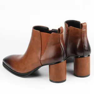 Rear view of brown burnished leather Chelsea boots with high block heel and side zipper
