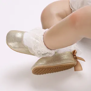 Detailed view of golden sparkling baby shoes with soft non-slip soles and lace ruffles