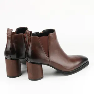 Detailed side view of men's brown leather Chelsea boots with high block heel and zipper