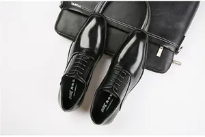 Detailed top view of black genuine leather men's Oxford dress shoes with polished finish