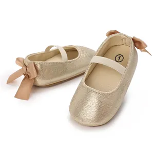 Detail of golden baby Mary Jane shoes with elastic strap and bow