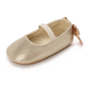 Macro detail of champagne gold baby shoes with bow and non-slip soft silicone sole