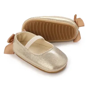 Close-up of gold glitter baby shoes showing anti-slip soft sole and bow detail