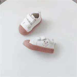 Close-up view of white children canvas shoes featuring a cute cartoon bear print