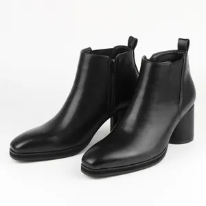 Detailed view of black leather men's Chelsea boots with side zipper and block heel