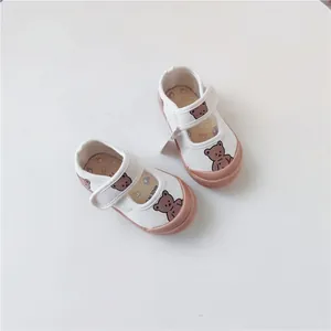 Detailed view of cute children's canvas shoes with bear pattern and a soft rubber sole