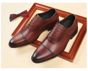Chaussures Oxford classiques en cuir bordeaux présentées avec un cadre en bois élégant