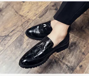 Vue détaillée de mocassins brogue en cuir verni noir avec glands et texture croco